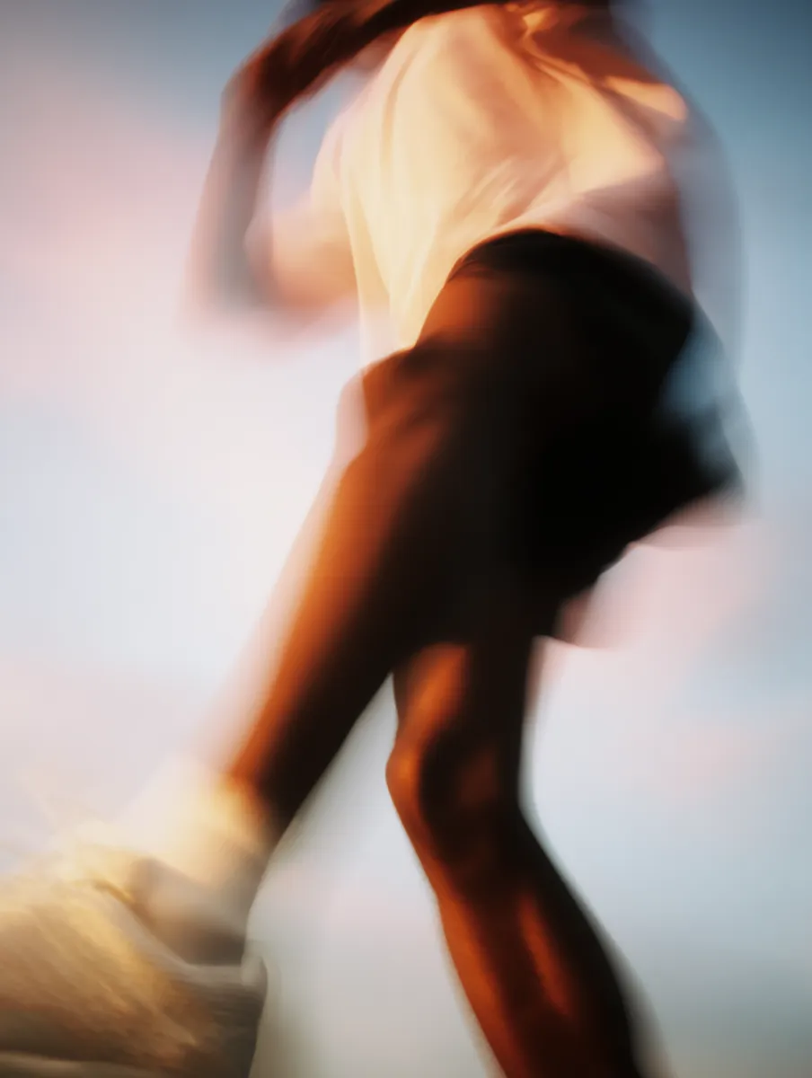 Long-exposure portrait dissolving into sunset orange